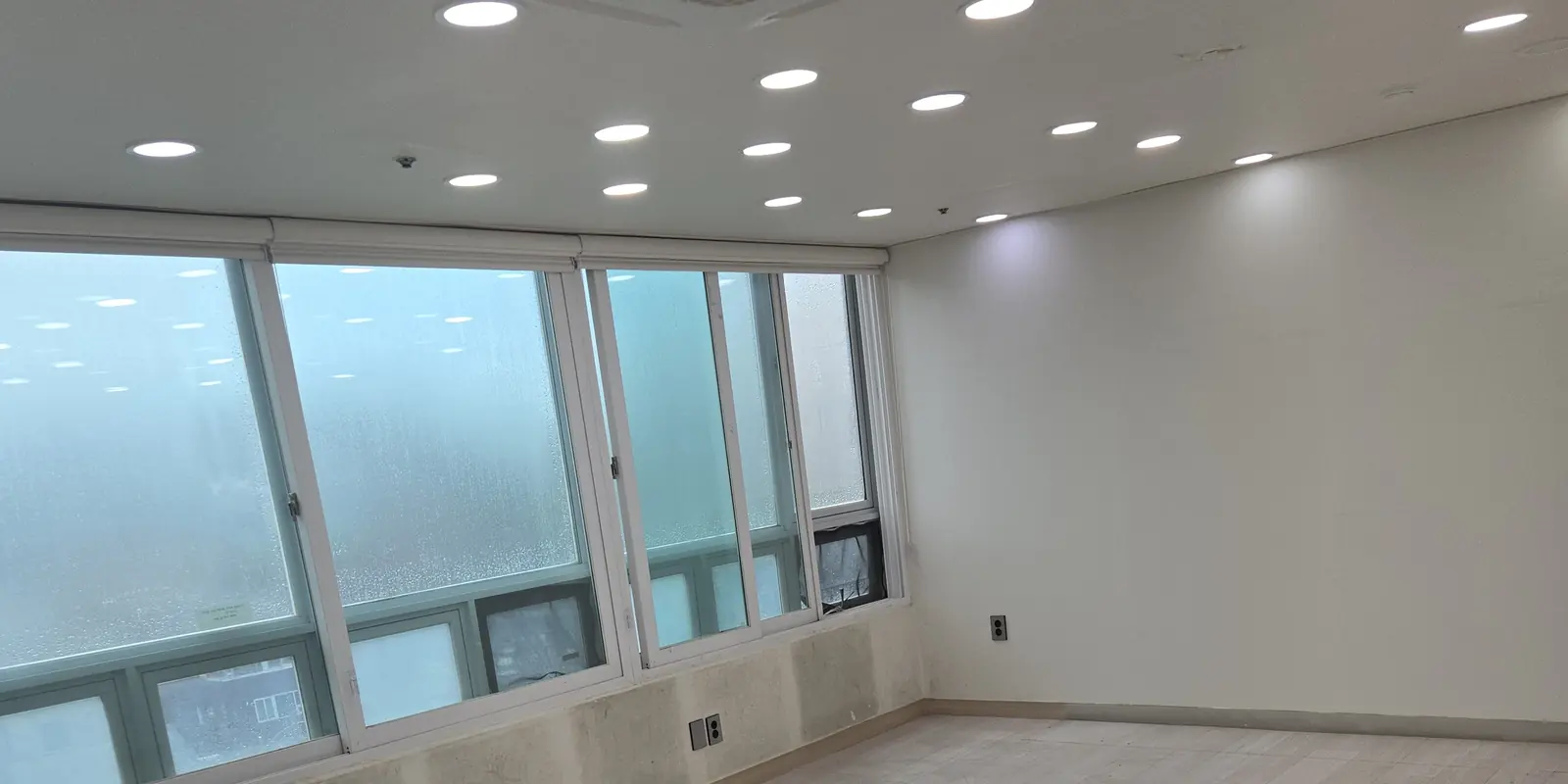 창가와 천장 조명이 보이는 넓은 빈 공간의 바닥