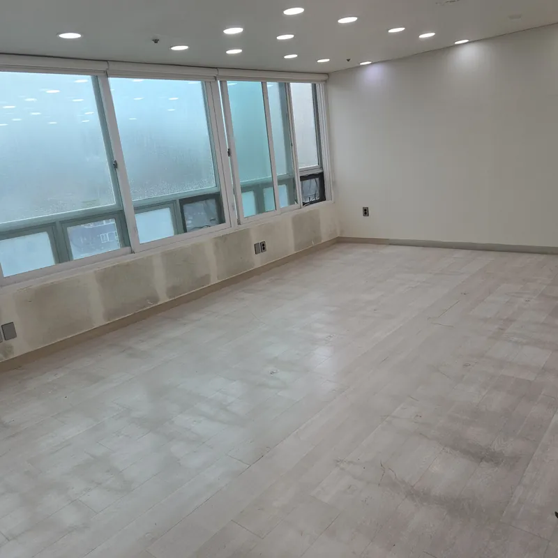 천장 에어컨과 조명이 보이는 창 있는 넓은 빈 공간
