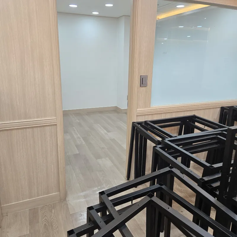 우드 문틀 앞쪽에 겹쳐 놓인 검정 철제 프레임